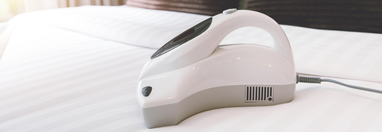 vacuum cleaner going over a mattress to clear away dust mites