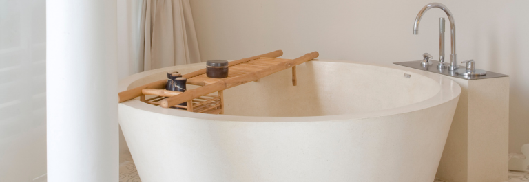 white bath with bamboo bath tray and silver tap