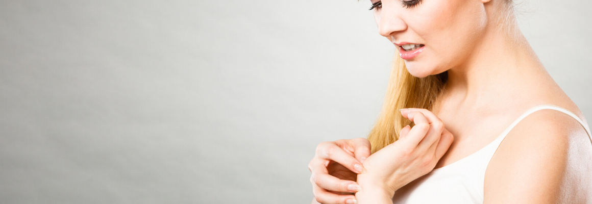 woman in white tank top scratching wrist