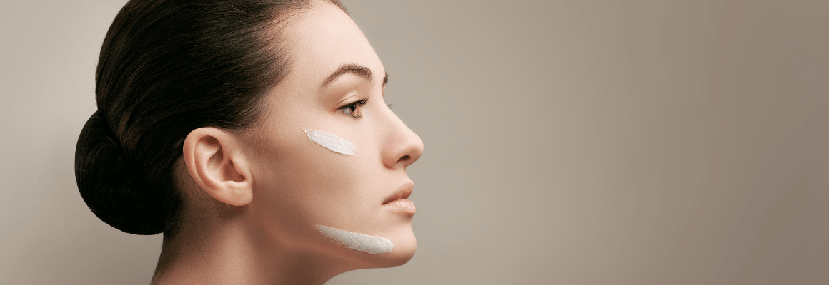 side profile of woman in tight bun with cream on face