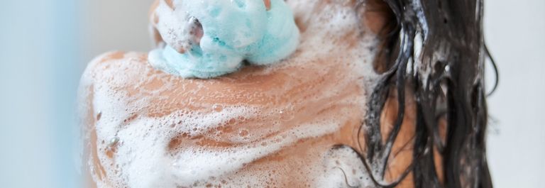 woman washing back - body wash for eczema