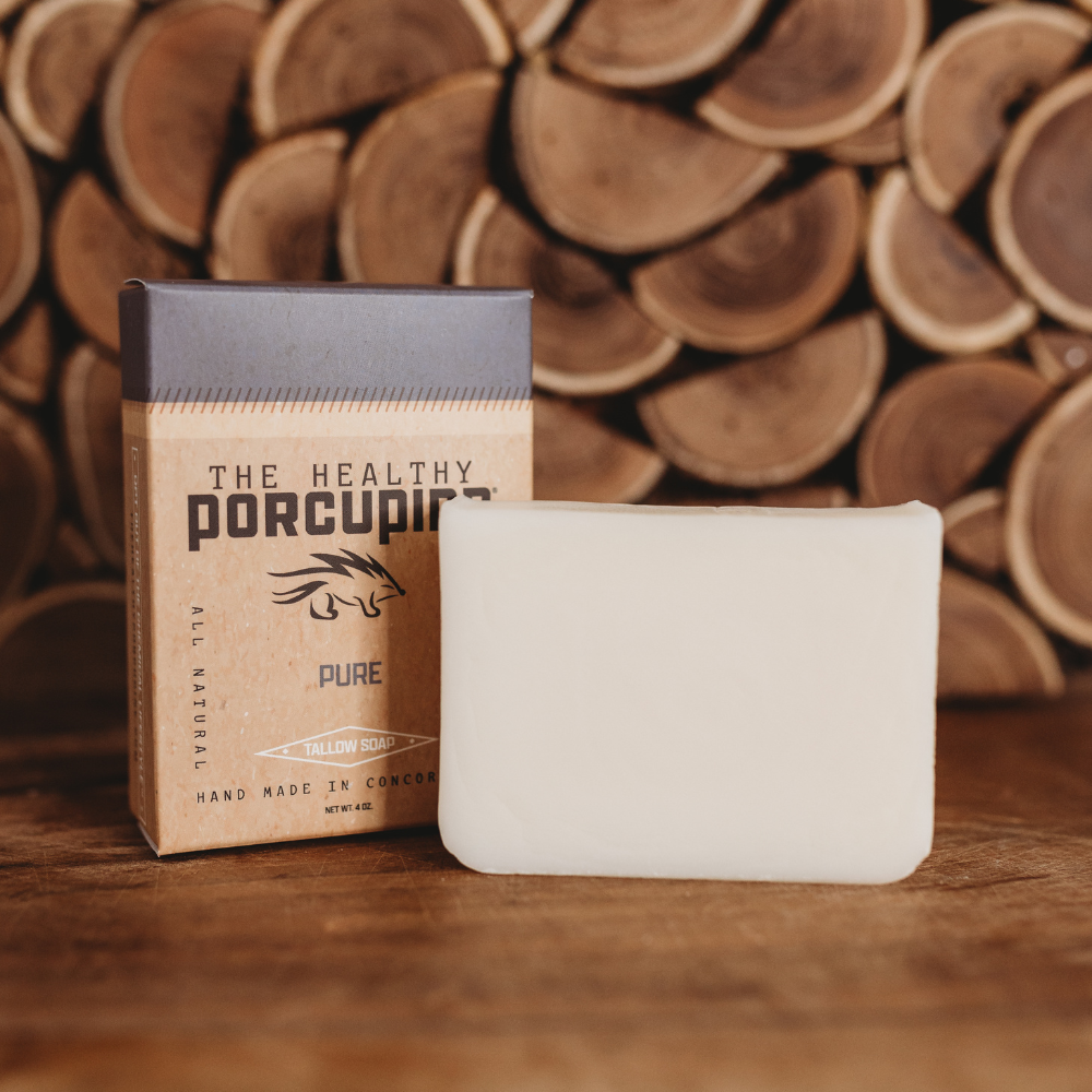 Bar of soap and packaging with 'The Healthy Porcupine' branding against a wooden background.