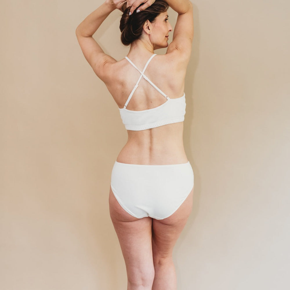Back view of a woman in a gentle organic cotton bikini with full seat coverage, ideal for sensitive skin