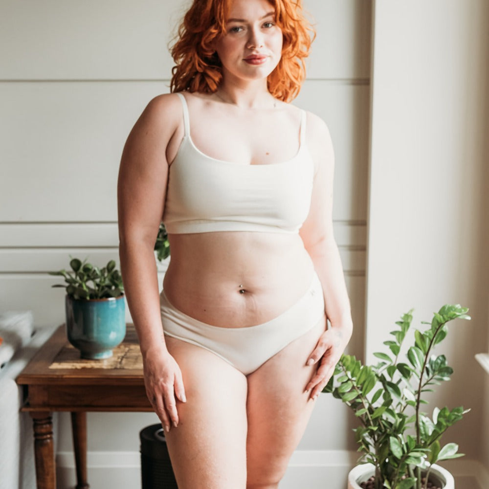 Curvy woman at home in a breathable organic cotton bikini and bralette, irritation-free everyday underwear