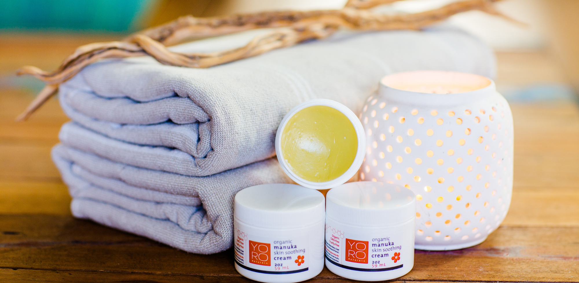 Manuka Cream with Candles and Towels on Table