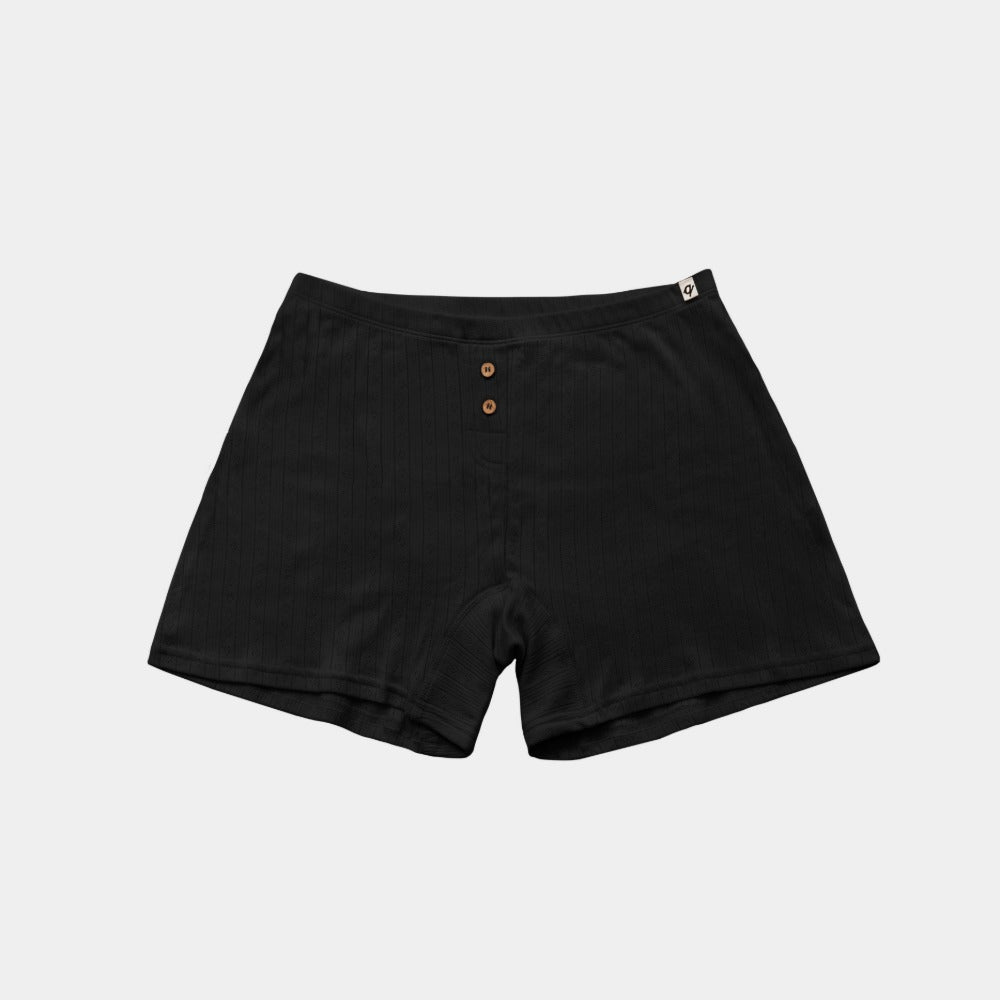 Black organic cotton pointelle boxers laid flat, breathable sleep shorts for eczema-prone skin