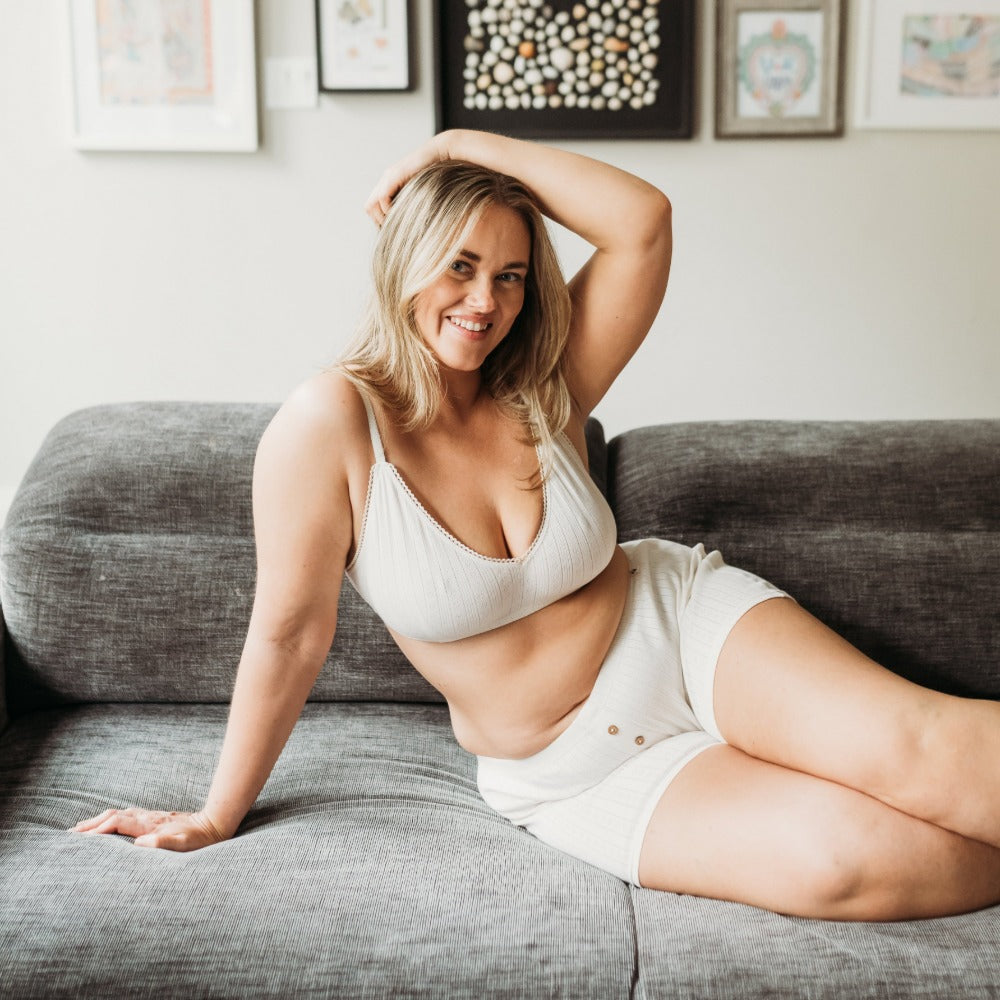 Woman relaxing on a couch in natural organic cotton boxers, cozy loungewear for eczema