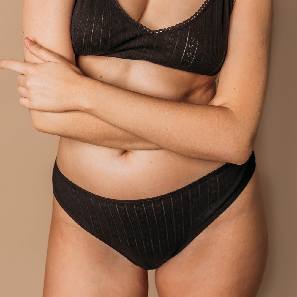Front view of a black pointelle thong and bralette in breathable organic cotton