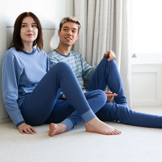Two adults wearing coordinating sets of tops and bottoms.