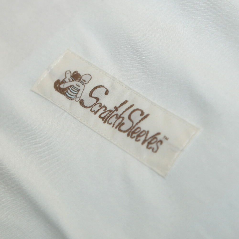 Close up of rectangularly shaped ScratchSleeves logo with baby and teddy bear embracing.