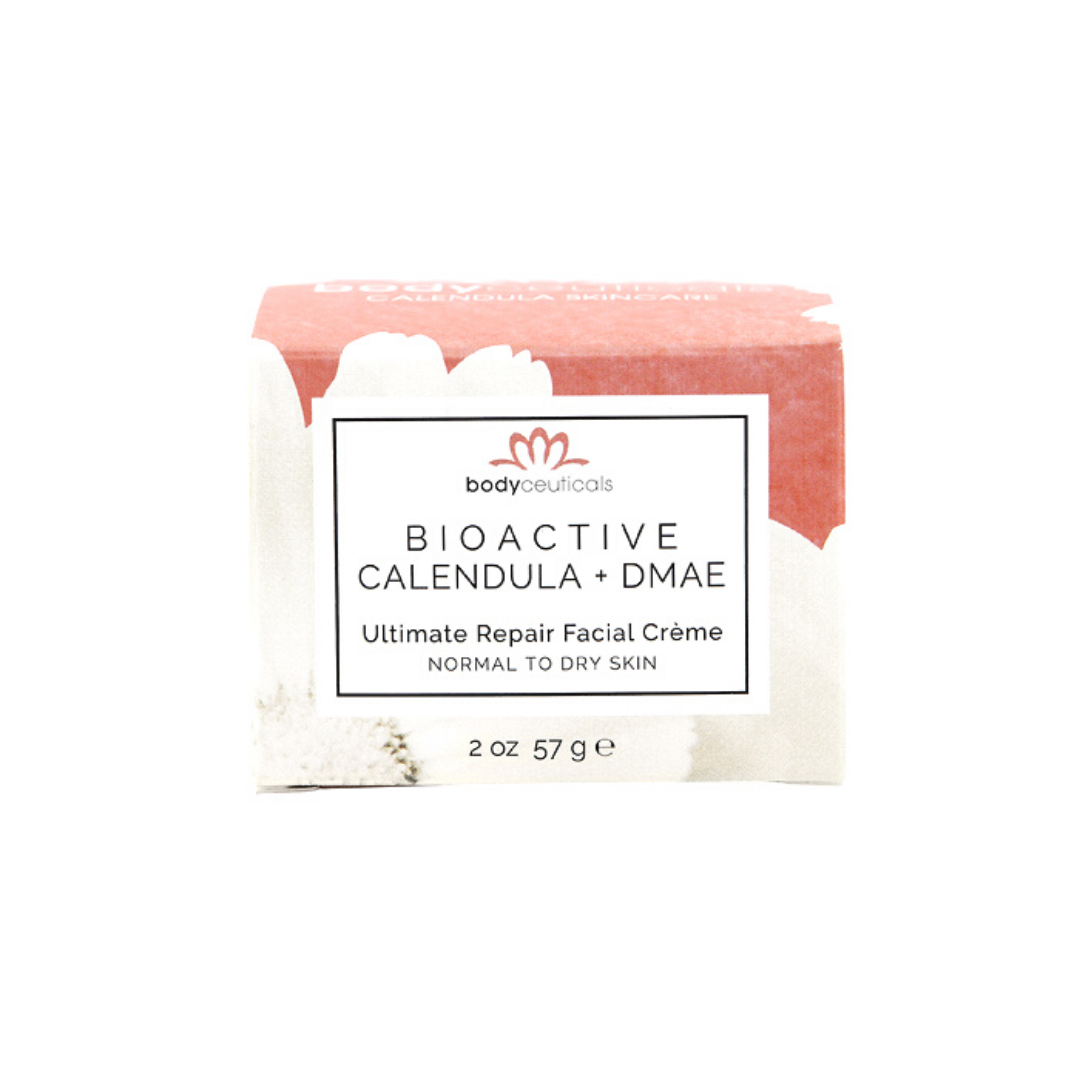 Box of the calendula facial cream with white calendula flowers and coral background.