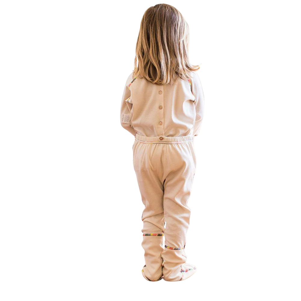 Back view of toddler girl standing with her one piece footie on.