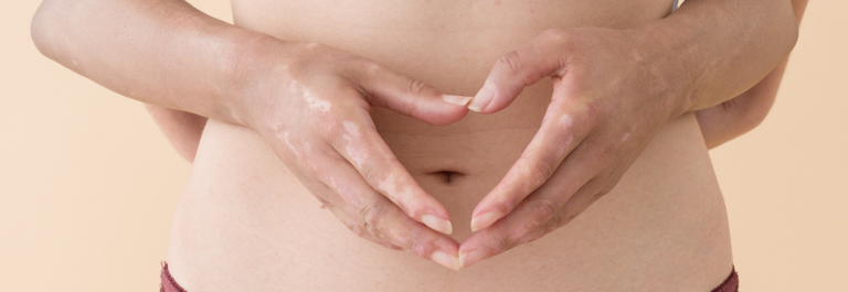 heart hands around a woman's bellybutton