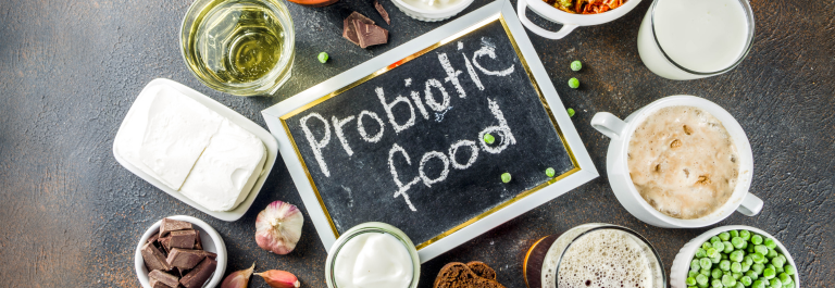 The words "Probiotic food" written on a blackboard, surrounded by probiotic food