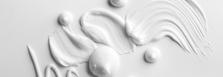 white dots and smears of cream on a white background.