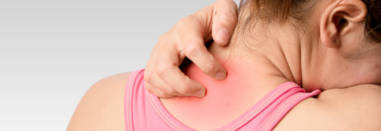 woman in pink tanktop scratching eczema on back