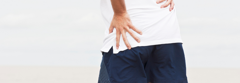 person in white shirt and navy shorts with hand on hips