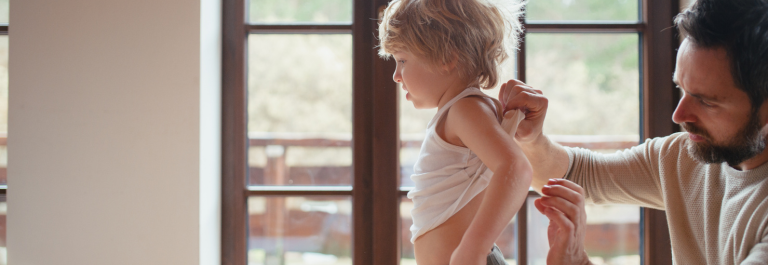 dad putting natural treatment on son's back : Frictional Lichenoid Dermatitis