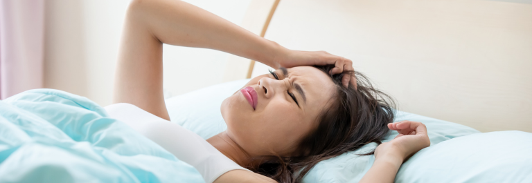 woman lying in bed frustrated because she can't sleep