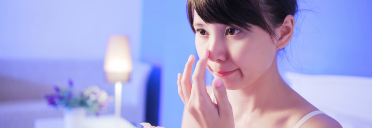 woman touching nose with soft blue lighting