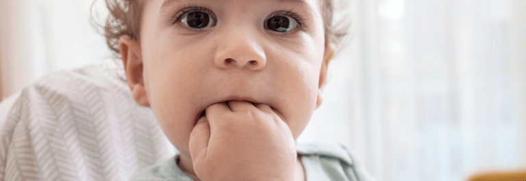 baby putting hands in mouth because of teething