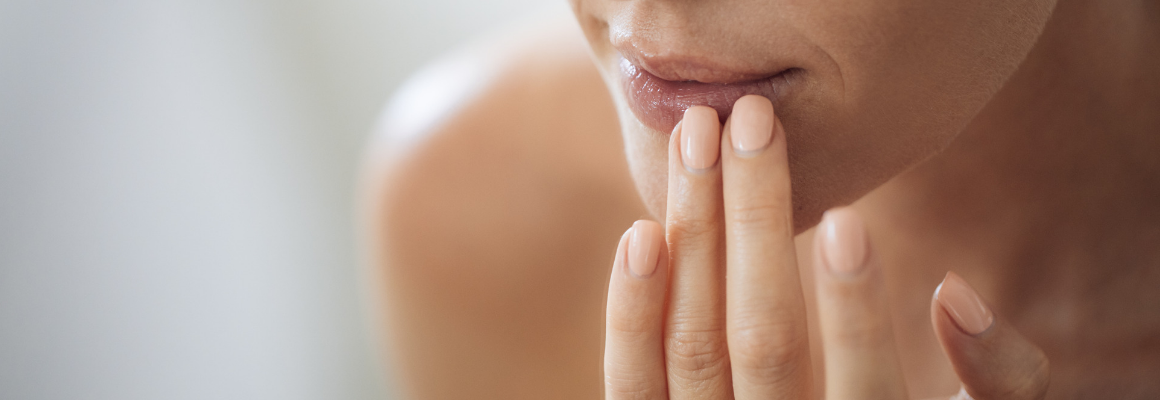 close up image of woman touching bottom of lip