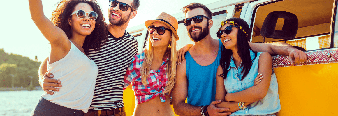 group of friends in front of camper van in summer
