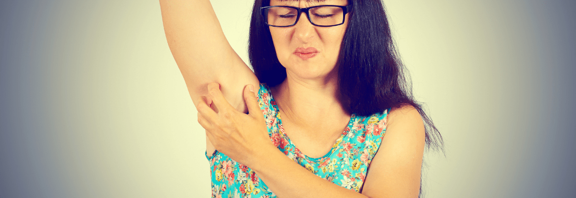 woman in glasses scratching armpit