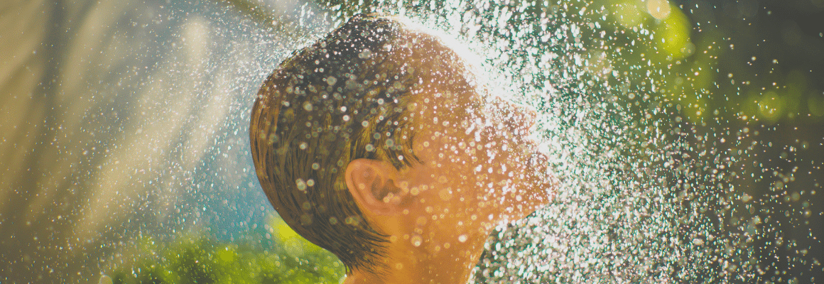 person standing under shower water - best eczema shower routine