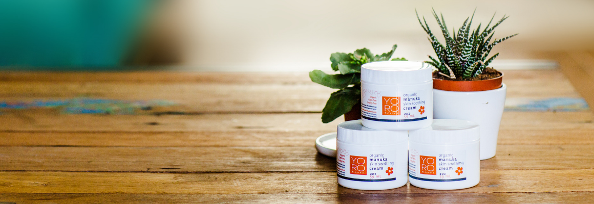 jars of organic manuka skin soothing cream with plants on wooden table