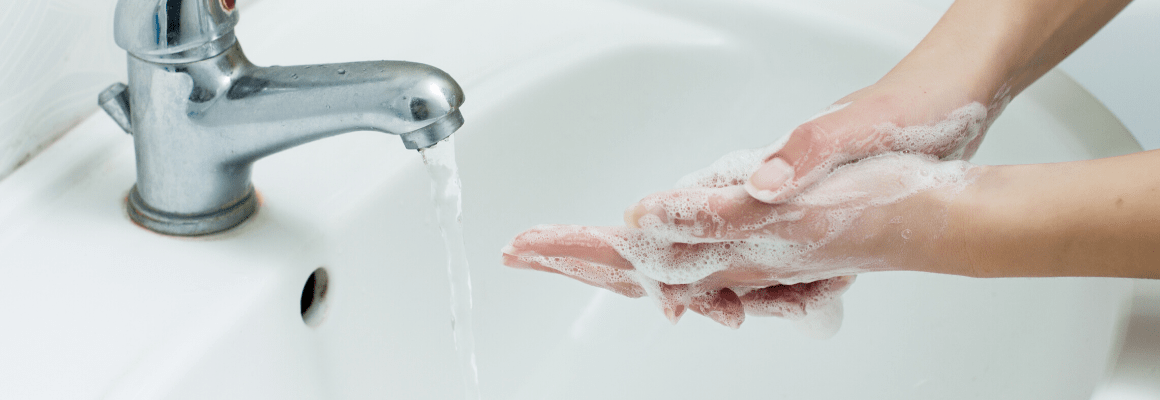 person watching hands in sink tap