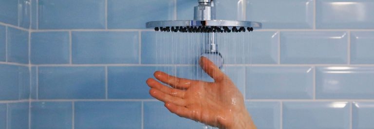 person running hand under shower - cold water for eczema 
