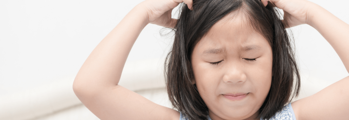 little girl with black hair scratching head
