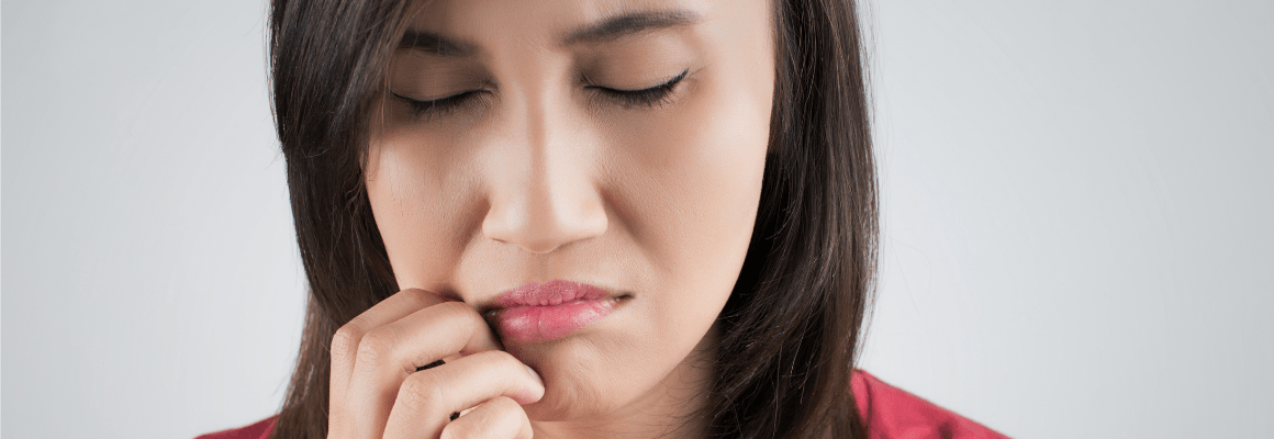 woman touching lips and chin in pain