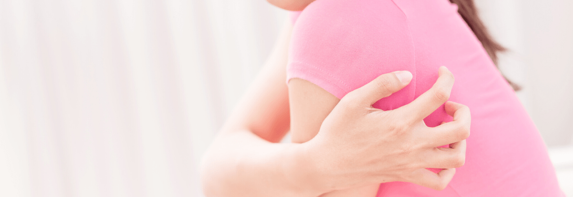 woman in pink shirt scratching back