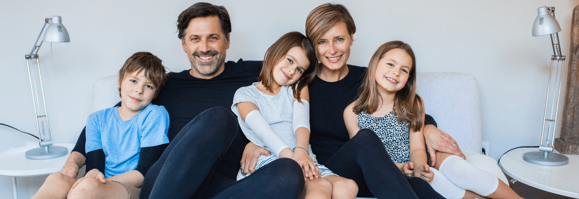 family sitting on bed (son, father, daughter, mother, daughter)