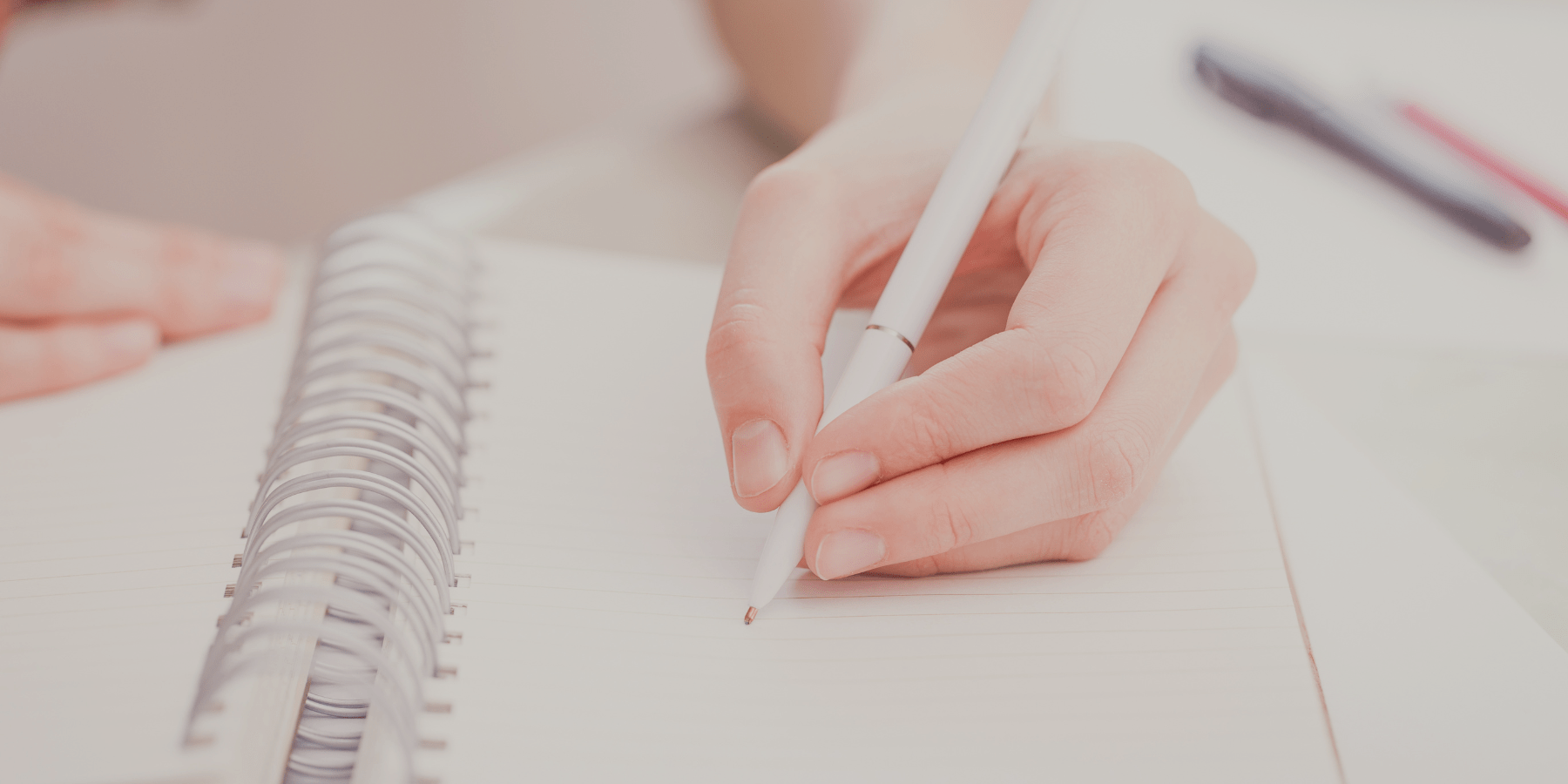 Woman writing in journal with white pen - elimination diet
