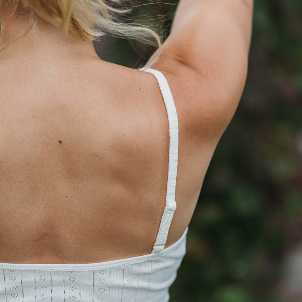 Adjustable strap detail on a natural pointelle tank top, smooth organic cotton to avoid itching