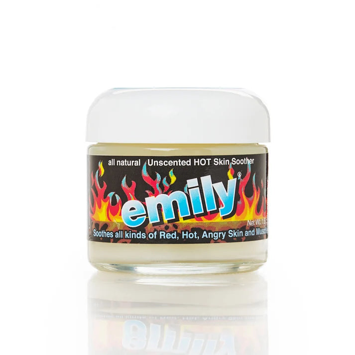 A small clear plastic jar of Emily Unscented Hot Skin Soother with a white lid and a black label featuring colorful flame graphics and the brand name 'emily' in large blue letters, shown on a white background with a reflection below.