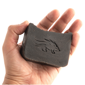 20% Pine tar soap with tallow in the palm of a man's hand.
