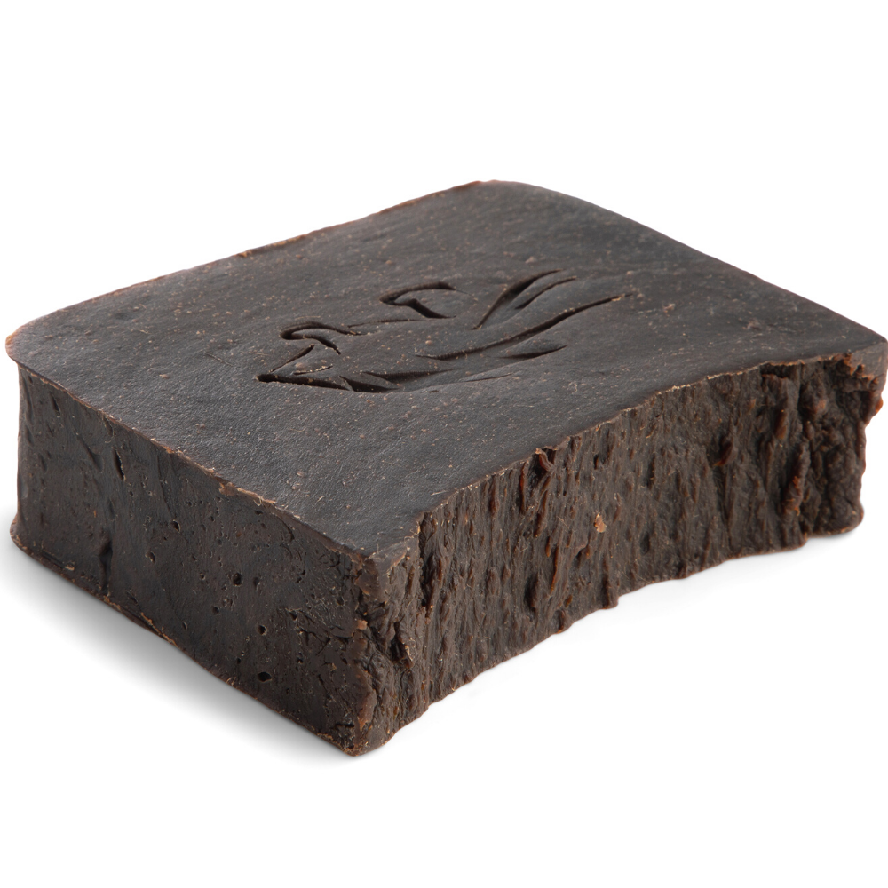 Close up of pine tar soap bar laying flat with porcupine logo etching.