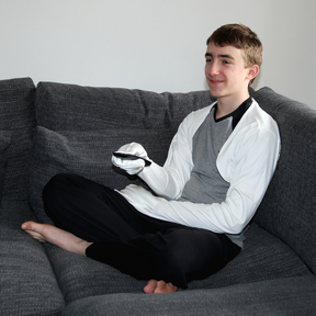 Boy holding a remove control while wearing white scratch sleeves.