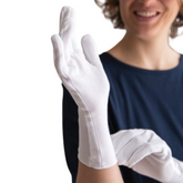 Woman wearing a pair of organic cotton gloves for adults in white.