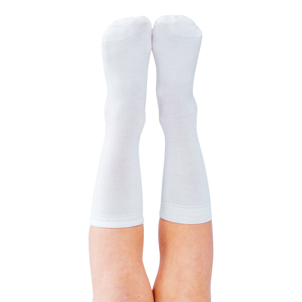 White Remeywear socks for eczema on two feet pointed in the air.