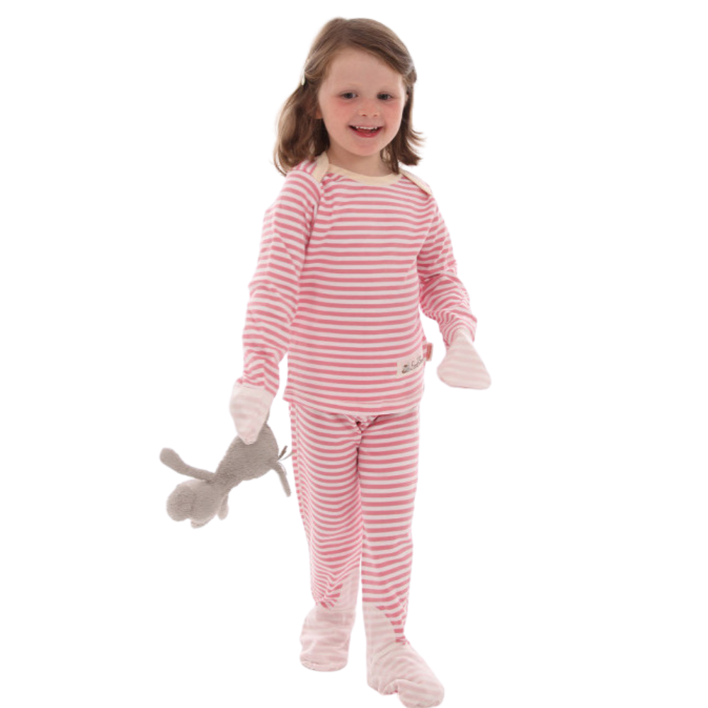 Toddler girl holding stuffed animal and wearing pink and white striped Scratchsleeves eczema pajamas. with silk covered mittens and toes.