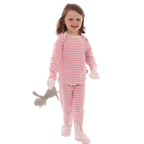 Toddler girl holding stuffed animal and wearing pink and white striped Scratchsleeves eczema pajamas. with silk covered mittens and toes.