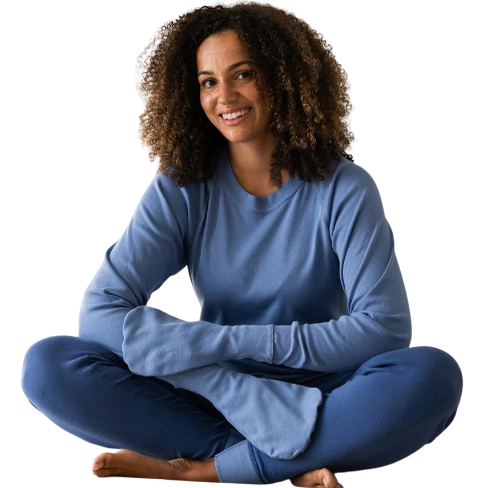 Woman sitting while wearing a medium blue top with closed eczema mittens