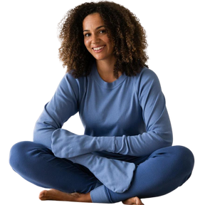 Woman sitting while wearing a medium blue top with closed eczema mittens