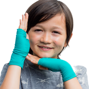 Boy framing his face with hands wearing teal Remedywear eczema gloves.